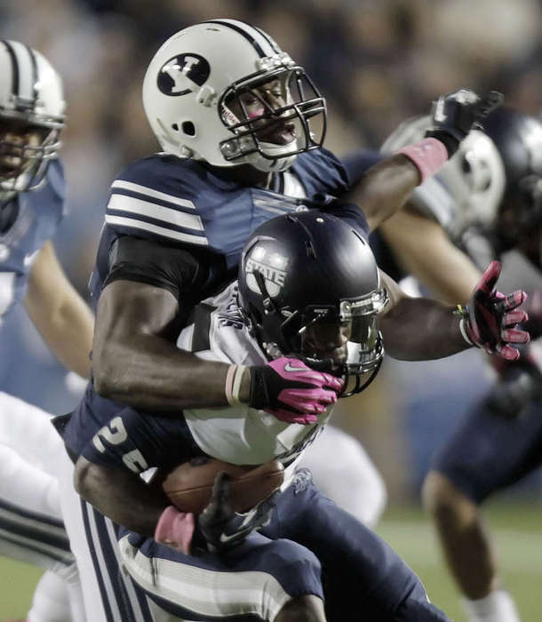 BYU's #47 Ezekial Ansah, left, brings down USU's #25 Kerwynn Williams for a loss. (Scott G. Winterton/Deseret News)