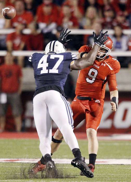 Utah quarterback Jon Hays (9) throws under pressure from Brigham Young Cougars linebacker Ezekiel Ansah (47). (Jeffrey D. Allred/Deseret News)