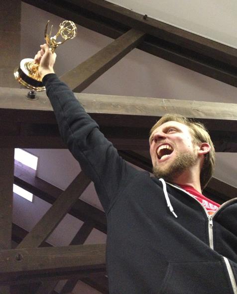 Kohl Glass holding up his Emmy Award.