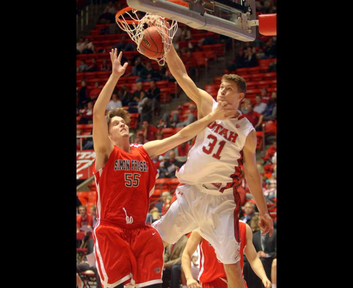The University of Utah's Dallin Bachynski (#31) dunks the ball over Simon Fraser's Keegan Dunlop (Kristin Murphy, Deseret News)