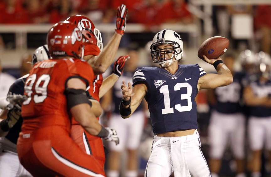 Brigham Young Cougars quarterback Riley Nelson (13) throws by Utah Utes defensive end Joe Kruger (99) (Jeffrey D. Allred, Deseret News)