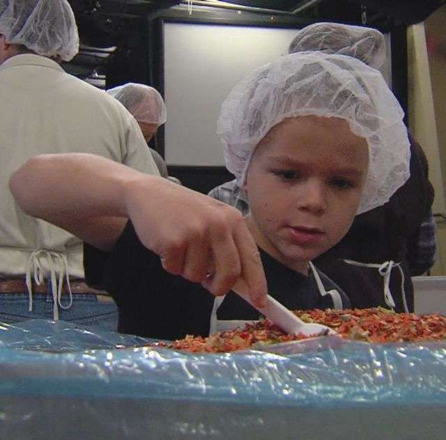 Tanner Gulledge, 10, works to package dried vegetables that will soon be shipped off to Africa to feed children in Swaziland.