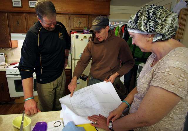 Electrician Kevin Adams, center, talks with Jeff and Diana Hanke about the addition to their home Wednesday, Nov. 21, 2012. The Hankes had planned to build the addition themselves, but Diana Hanke was recently diagnosed with cancer. Now volunteers using donated materials and funds are building it for the family. (Photo: Geoff Liesik, Deseret News)