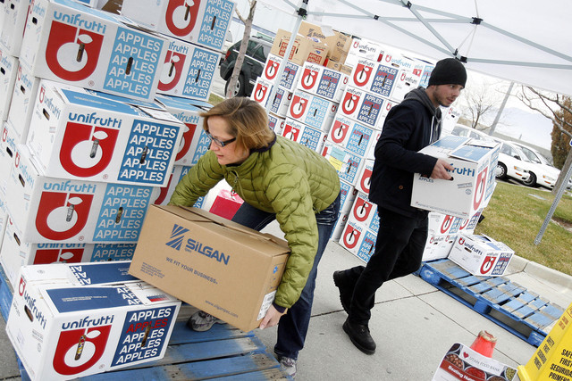 Amy Rich and David Clark volunteer their time giving out boxes of bread at the Utah Food Bank in Salt Lake City on Wednesday, Dec. 5, 2012. Food insecurity rates jumped up to nearly 10% in Utah at points during the pandemic due, in part, to food assistance becoming difficult for some to access. 