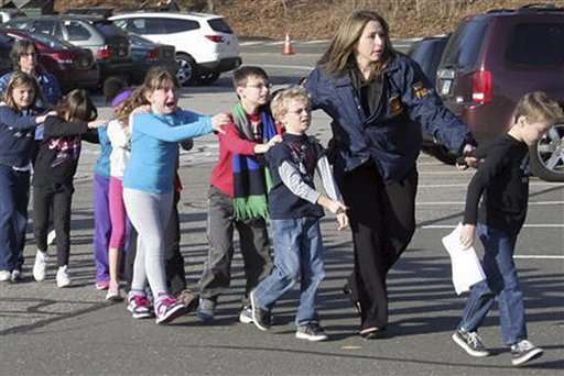 In this photo provided by the Newtown Bee, Connecticut State Police lead children from the Sandy Hook Elementary School in Newtown, Conn., following a reported shooting there Friday, Dec. 14, 2012. (AP Photo/Newtown Bee, Shannon Hicks)