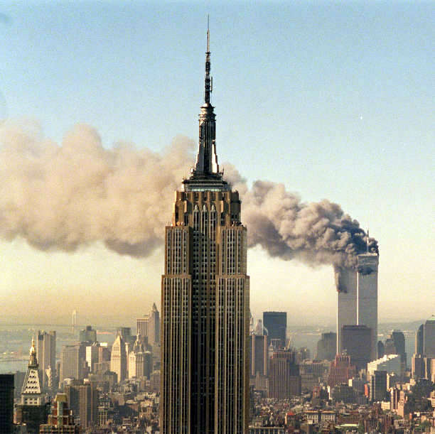 FILE - In this Sept. 11, 2001 file photo, the twin towers of the World Trade Center burn behind the Empire State Building in New York. (AP Photo/Marty Lederhandler, File)