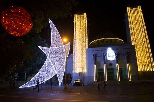 People walk past a display of Christmas decorations at the Cathedral in central Dakar, Senegal. (AP Photo/Rebecca Blackwell)