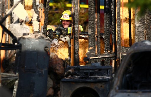 Firefighters look through the remains of Josh Powell's home