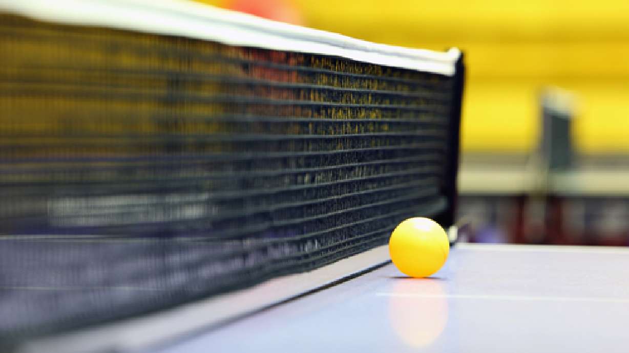 Businesses network over ping pong table