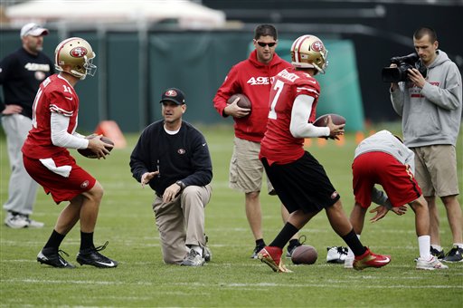 San Francisco 49ers head coach Jim Harbaugh, center, instructs quarterback Alex Smith, left, and quarterback Colin Kaepernick (7) (AP Photo/Marcio Jose Sanchez)