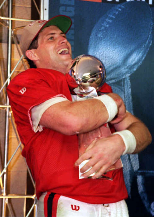 San Francisco 49ers quarterback Steve Young (8) hugs the MVP trophy at Miami's Joe Robbie Stadium Sunday, Jan. 29, 1995. Young lead the 49ers to a 49-26 victory over the San Diego Charger in Super Bowl XXIX. (AP Photo/Eric Risberg)