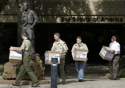 In this Feb. 4, 2013, photo Eagle Scout Will Oliver, from left, former Scoutmaster Greg Bourke, former den leader Jennifer Tyrrell and Eric Andresen, right, a parent of a gay scout deliver boxes filled with a petition to the statue in front of the Boy Scouts of America headquarters in Irving, Texas.