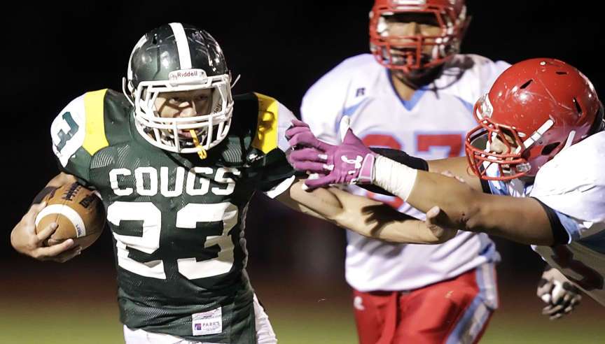 Kearns' James Felila, left, tries to give a straight arm to Granger's #23 Marshal Auvaa as Kearns and Granger play Wednesday, Oct. 17, 2012 at Kearns. Felila signed with SUU.