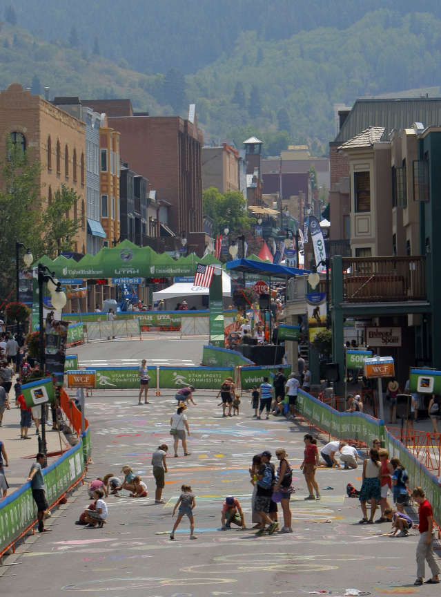 Crowd members use chalk to draw pictures and signs on Main street during stage 6 of the Tour of Utah Sunday, Aug. 12, 2012 Park City to Park City.