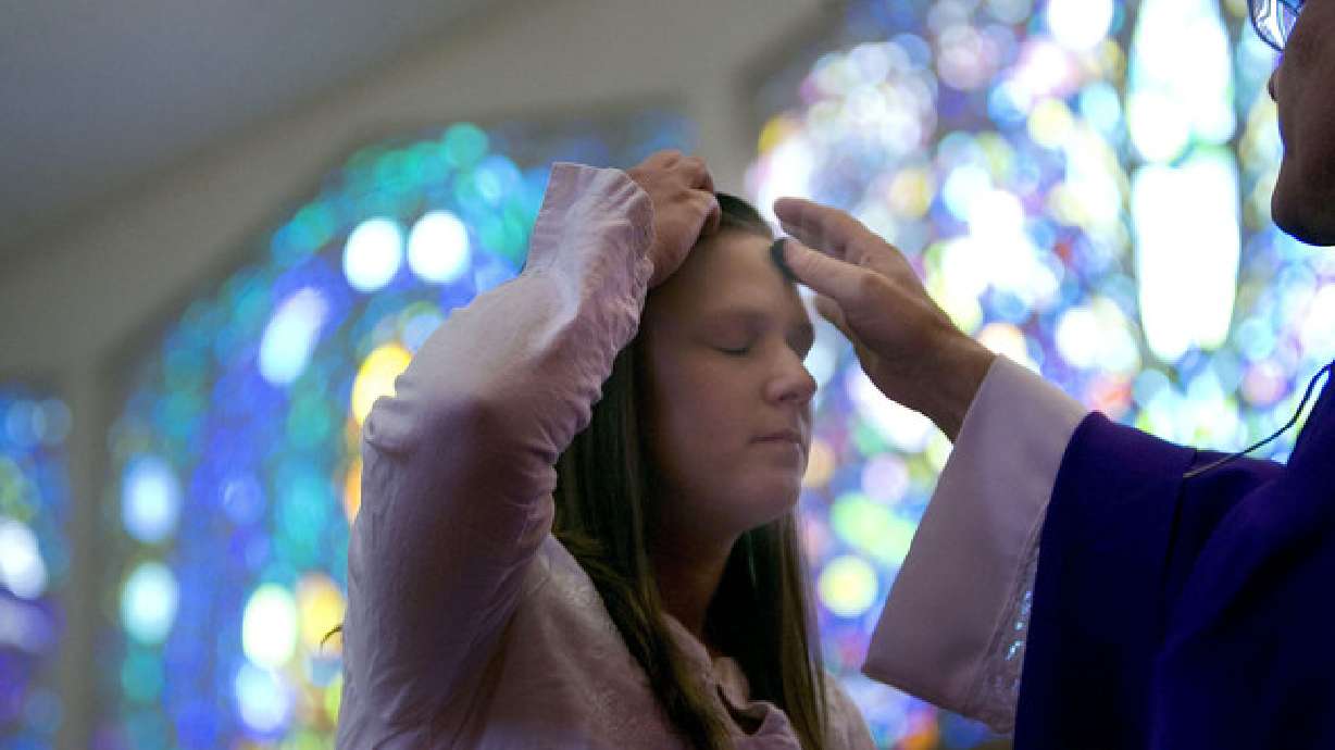 A woman receives ashes from Deacon George Reade at St. Ambrose Catholic Church in Salt Lake City on Ash Wednesday, Feb. 13, 2013. Some Ash Wednesday services were canceled or moved online this year because of the major snowstorm moving across the Wasatch Front.