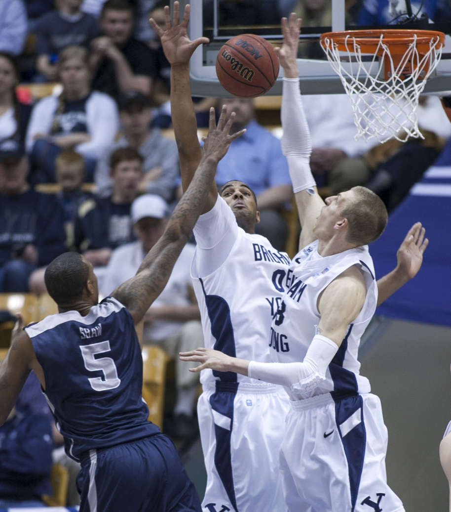 BYU's Brandon Davies and Nate Austin defend a shot by USU's Jarred Shaw as BYU and Utah State play Tuesday, Feb. 19, 2013 at BYU in the Marriott Center.
