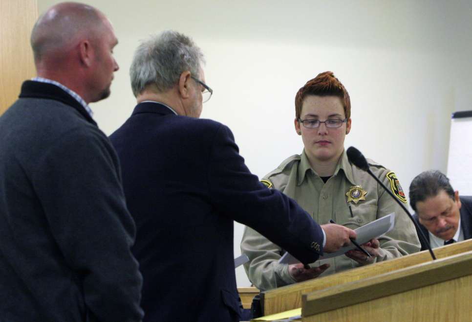 Defense attorney Loni DeLand hands a plea agreement signed by his client, former Vernal police detective Ben Murray, to a Duchesne County sheriff\'s bailiff in 8th District Court Thursday, Feb. 21, 2013. Murray pleaded no contest to one count of unlawful use of controlled substance database information and guilty to one count of possession or use of a controlled substance. Murray was sentenced to serve 18 months probation. (Photo: Geoff Liesik, Associated Press)