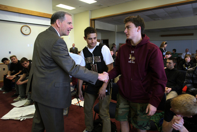 Alpine School District Superintendent Vernon M. Henshaw, left, shakes hands with Lone Peak football players Caden Humphrey and Parker Richards. Football players, students and some parents from Lone Peak High School walked from the school to Alpine School District offices in support of the former Lone Peak coach Tony McGeary, Monday, March 4, 2013. (Ravell Call, Deseret News)
