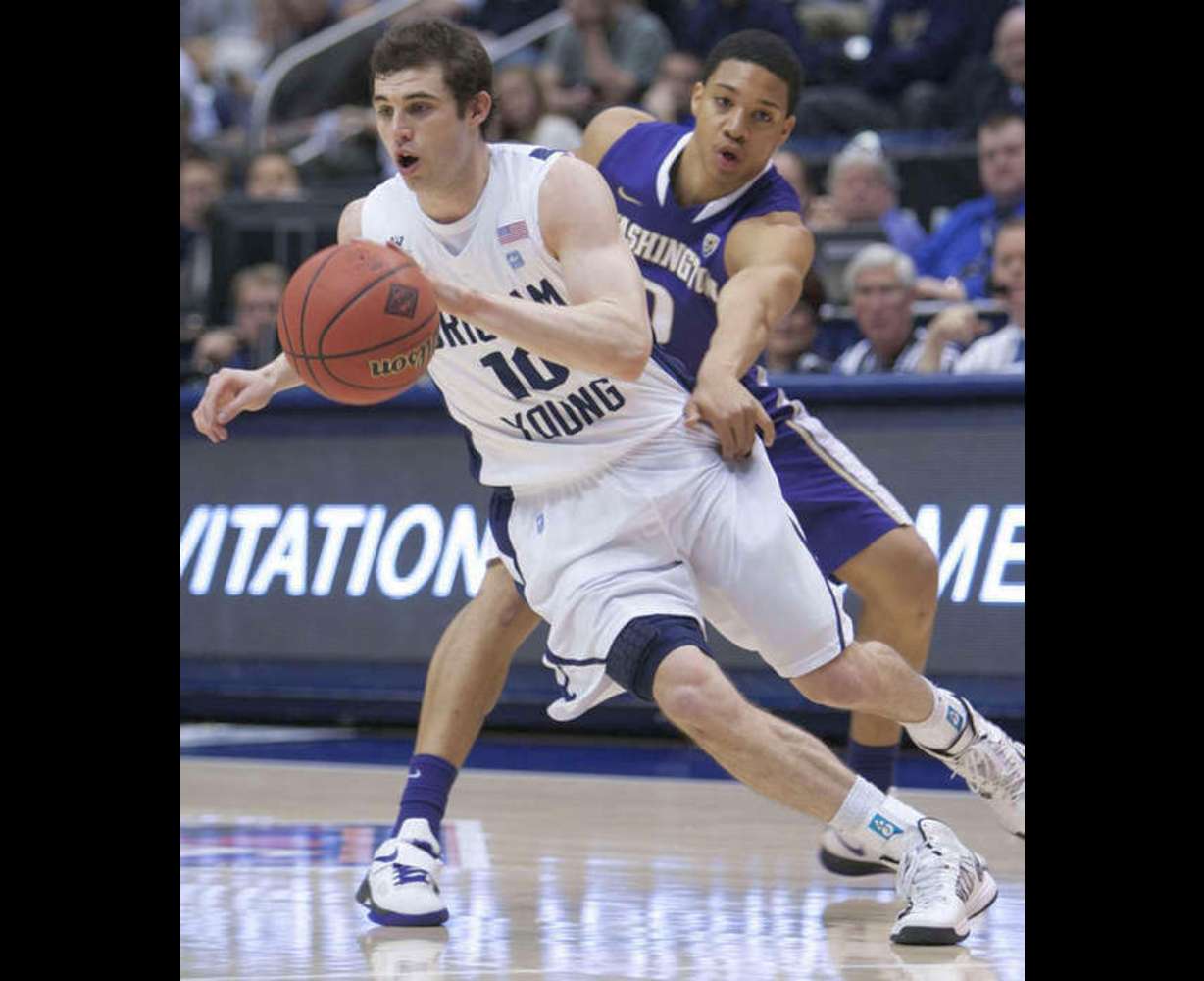 BYU's Matt Carlino dribbles away from Washington's Abdul Gaddy as BYU and Washington play in the first round of the NIT in the Marriott Center at BYU. (Scott G. Winterton/Deseret News)