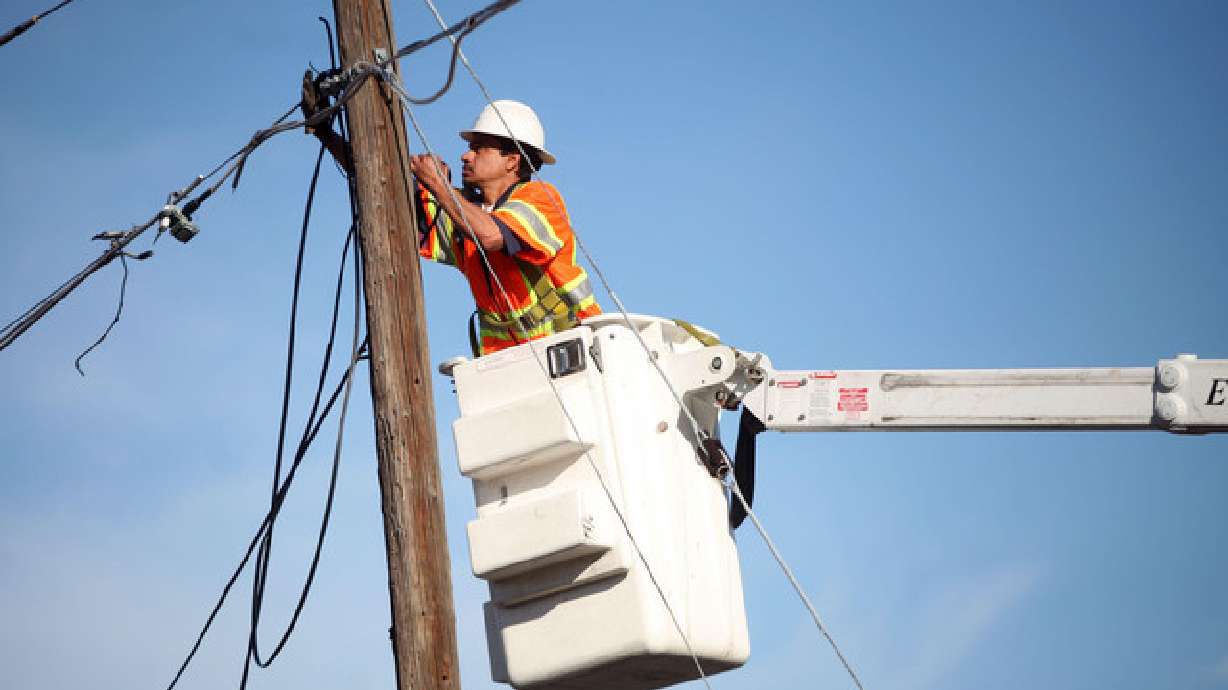 Ignacio Garcia fixes cable lines after a fire in Murray on April 4, 2013. U.S. land managers have given final permissions for a 416-mile transmission line that would connect wind farms in eastern Wyoming with customers in Utah and elsewhere across the West.