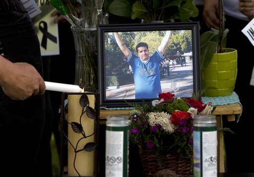A mourner light candles at a makeshift memorial before a news conference by the family to discuss the death of Ricardo Portillo, who passed away after injuries he sustained after an assault by a soccer player at a soccer game he was refereeing on April 27, in Salt Lake City on Sunday, May 5, 2013. (AP Photo/The Salt Lake Tribune, Kim Raff)
