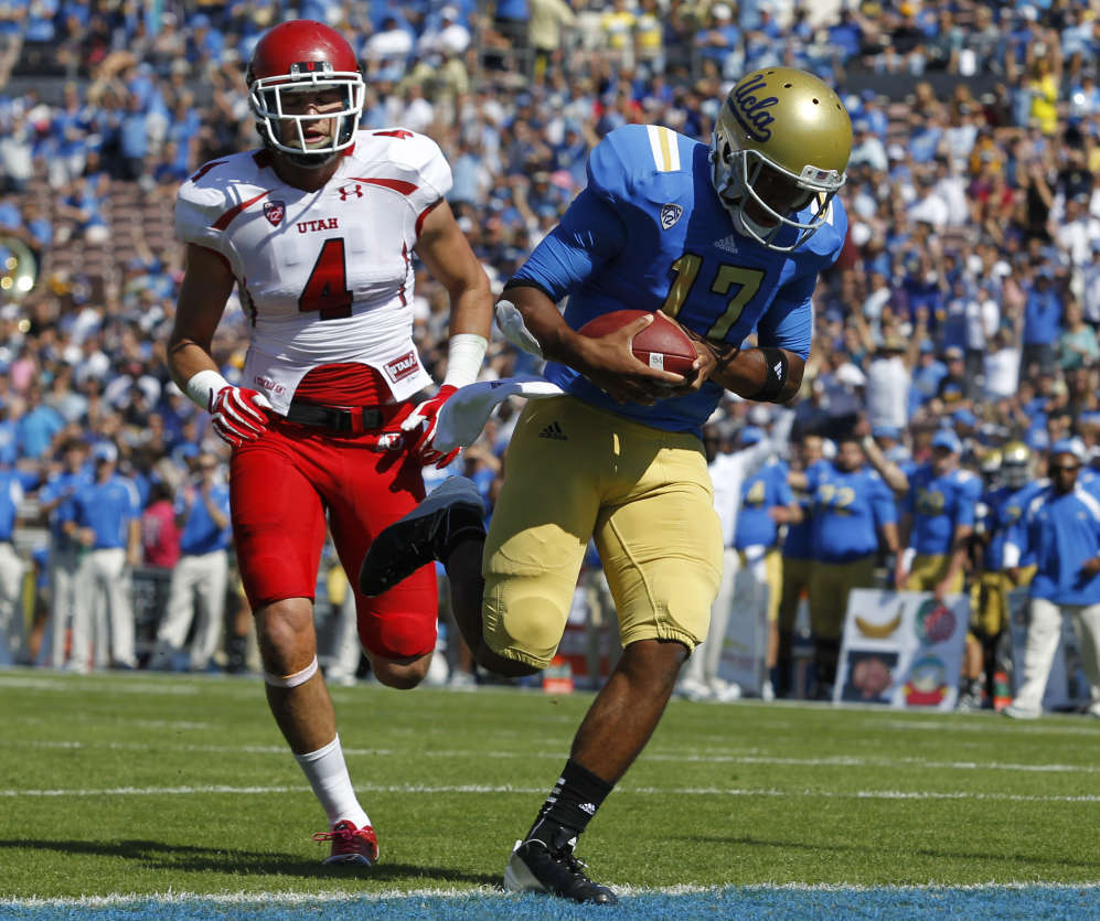 UCLA quarterback Brett Hundley, right, runs in 
for a 12-yard touchdown against Utah (AP 
Photo/Alex Gallardo)