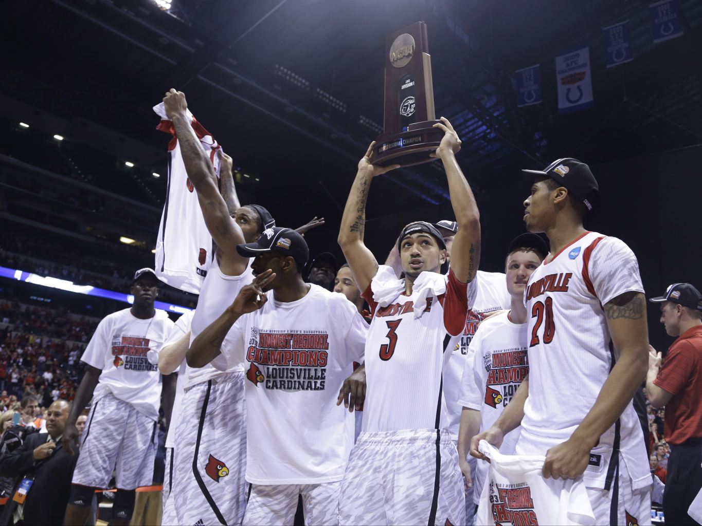 Louisville guard Peyton Siva (3) holds up the regional trophy as Louisville players celebrate their 85-63 win over Duke in the Midwest Regional final in the NCAA college basketball tournament, Sunday, March 31, 2013, in Indianapolis. (AP Photo/Michael Conroy)
