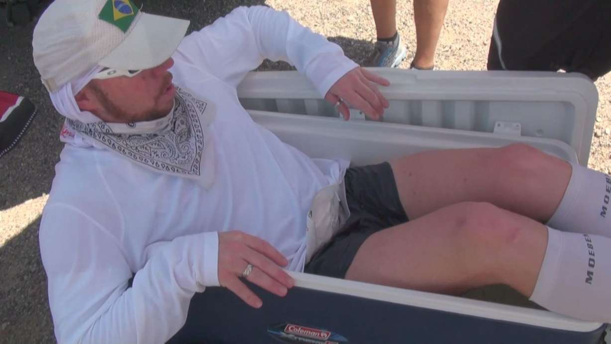 Jarom Thurston's crew has him sit in an ice
bath to cool him down after running for nearly
50 miles in 120-degree weather.