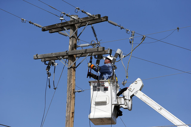 A Rocky Mountain Power employee works on power lines in Utah in 2013. The company said it is investigating the cause of an outage in Salt Lake County Sunday.