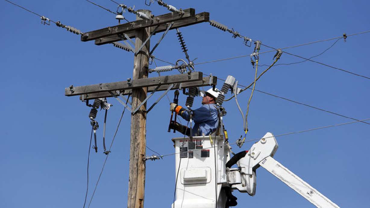 A Rocky Mountain Power employee works on power lines in Utah in 2013. The company said it is investigating the cause of an outage in Salt Lake County Sunday.