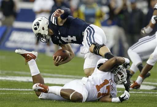 Texas safety Adrian Phillips (17) tackles Brigham Young quarterback Taysom Hill (4) in the first half during an NCAA college football game Saturday, Sept. 7, 2013, in Provo, Utah. (AP Photo/Rick Bowmer)