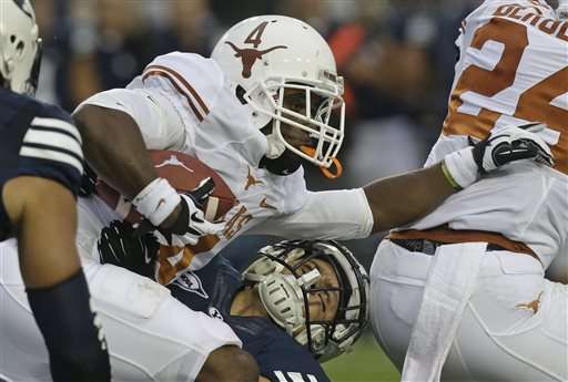Brigham Young linebacker Alani Fua (5) tackles Texas running back Daje Johnson (4) in the first quarter during an NCAA college football game Saturday, Sept. 7, 2013, in Provo, Utah. (AP Photo/Rick Bowmer)
