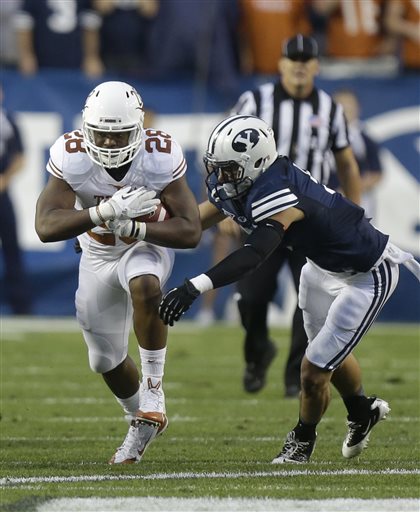 Texas running back Malcolm Brown (28) carries the ball as Brigham Young linebacker Alani Fua (5) makes a tackle in the first quarter during an NCAA college football game Saturday, Sept. 7, 2013, in Provo, Utah. (AP Photo/Rick Bowmer)