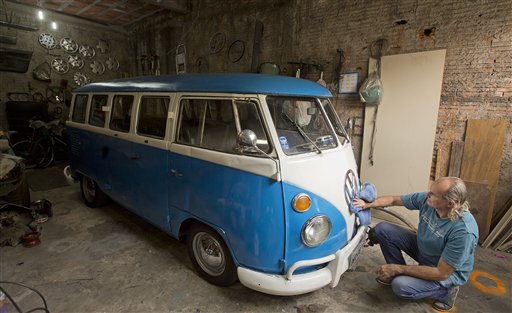 In this Sept. 16, 2013 photo, Enio Guarnieri
wipes the VW emblem of his 1972 Volkswagen van,
in Sao Paulo, Brazil. (AP Photo/Andre Penner)