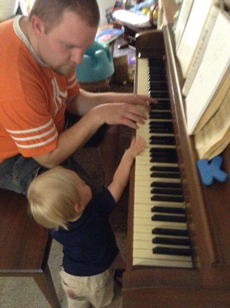 Kurt Reeder practices the piano with his son.