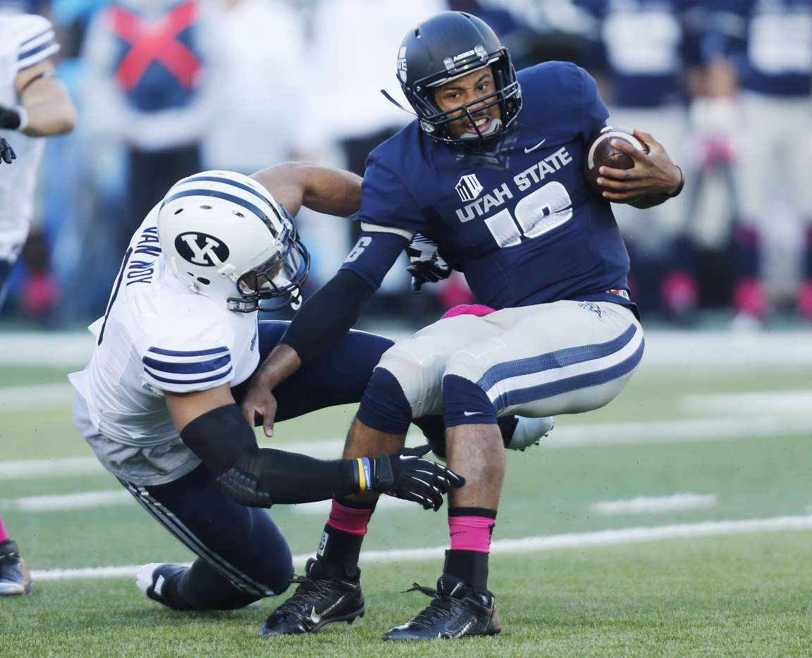 Utah State Aggies quarterback Chuckie Keeton (16) against Brigham
Young Cougars linebacker Kyle Van Noy (3) during NCAA football
game in Logan Friday, Oct. 4, 2013. Keeton was injured and had to
leave the game . (Submission date: 10/04/2013)