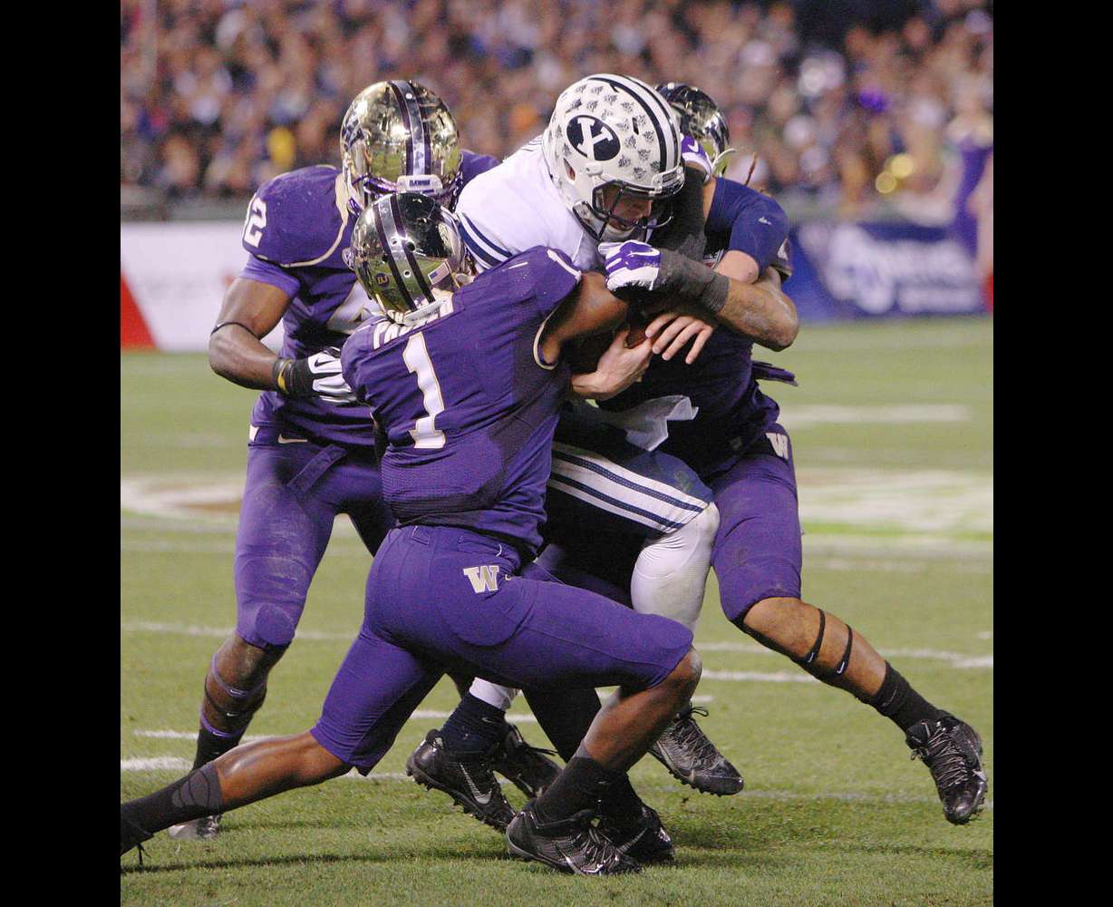 Brigham Young Cougars quarterback Taysom Hill (4) runs against
Washington Huskies defensive back Sean Parker (1) during the Fight
Hunger Bowl in San Francisco Friday, Dec. 27, 2013.