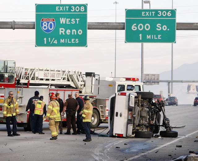 Utah Highway Patrol Troopers work Monday, Dec.
30, 2013 to clean up a single vehicle rollover
on I-15.