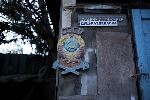 In this photo taken on Wednesday, Nov. 27,
2013, the colored state emblem of the USSR
hangs on the door of the outhouse in the yard
of the railroad house in the village of
Vesyoloye outside Sochi, Russia. Signs read
"Chief engineer; Showers." As the Winter
Games are getting closer, many Sochi
residents are complaining that their living
conditions only got worse and that
authorities are deaf to their grievances.