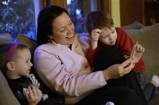 Julie Young, a Boston-based behavioral 
analyst, center, sits with her sons Nolan, 3, 
left, and Jameson, 4, right, while looking at 
a smart phone at their home, in Boston, 
Monday, Jan. 27, 2014. Child development 
experts say it's natural for toddlers to be 
fascinated with their own image, and that 
interest plays an important developmental 
role as they develop a sense of self. (AP 
Photo/Steven Senne)