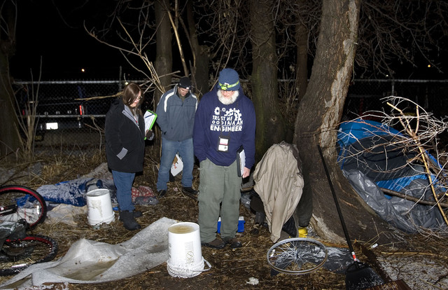 Lora Bawden of Americorps, Salt Lake City
Police Officer Sam Wolf of the Homeless
Outreach Service Team, and Larry Mullin of
Volunteers of America attempt to speak with
people living in tents in a parking lot during
the annual Point-In-Time Count of the homeless
population in Salt Lake City on Thursday, Jan.
30, 2014.