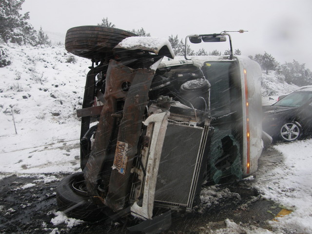 Semitruck tips over on I-15, vehicle slides into it