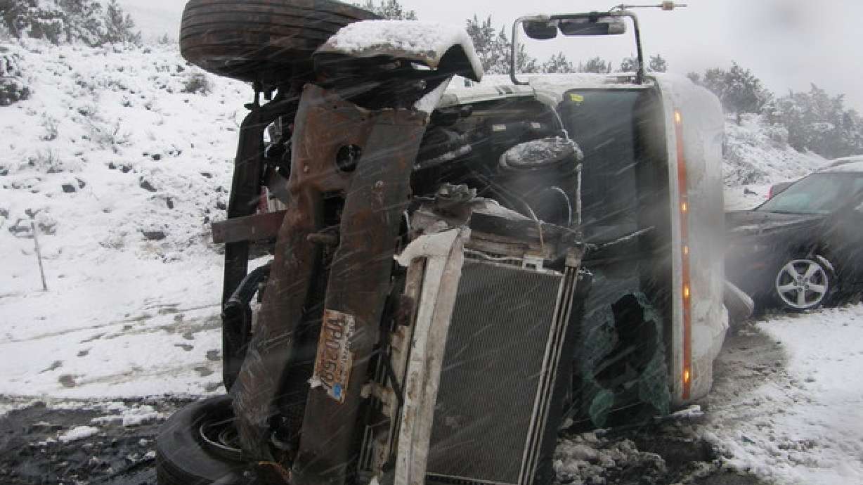 Semitruck tips over on I-15, vehicle slides into it
