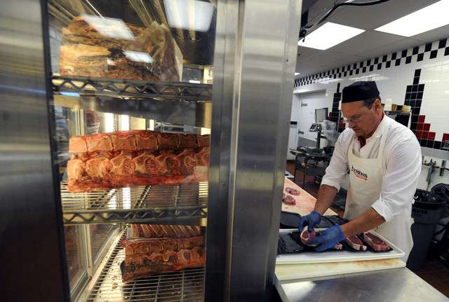 Michael Brookbank cuts meat in the meat
department at the Harmon's in Midvale, 7800 S
and 700 E, as it was Brookbank's first day at
work as an Assistant Meat Manager on Friday,
March 7, 2014.