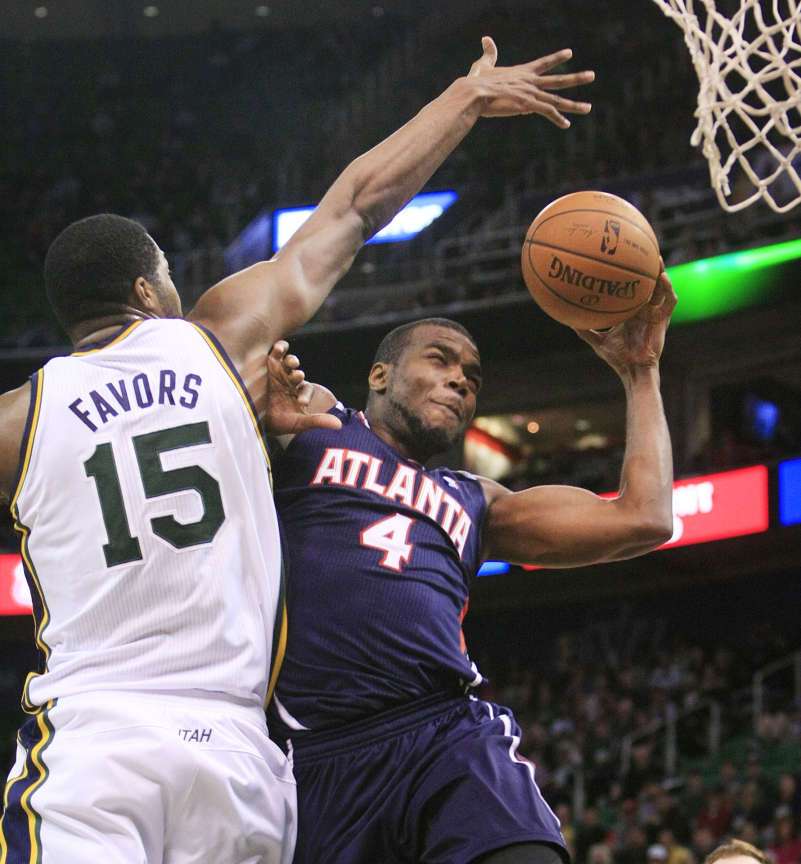 Utah Jazz's center Derrick Favors (15) is
whistled for a foul on Atlanta Hawks' power
forward Paul Millsap (4) as the Utah Jazz and
the Atlanta Hawks play Monday, March 10, 2014
in EnergySolutions Arena in Salt Lake City.
Hawks won 112-110.