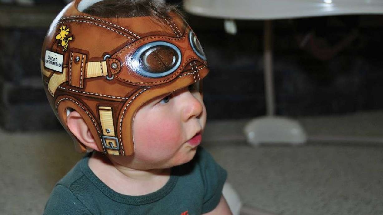 Artist paints colorful scenes on baby helmets