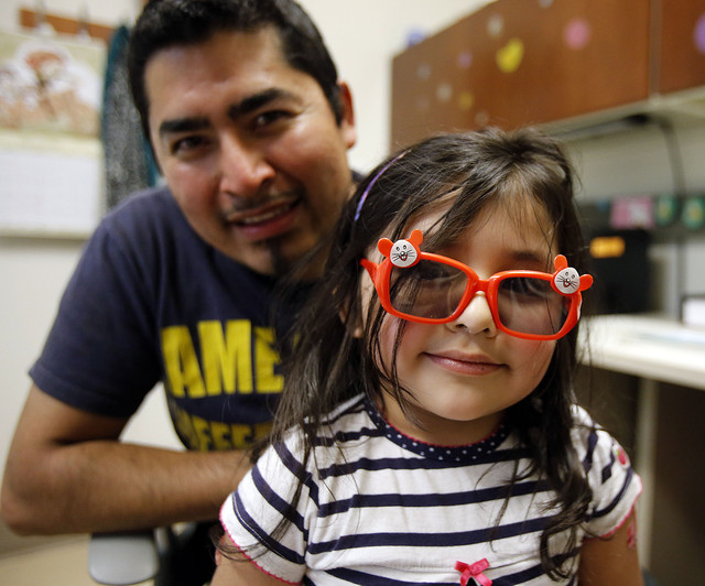 Gissel Astorga smiles after getting vaccinations and sunglasses at the
South Main Public Health Clinic in Salt Lake City on Tuesday, April 8,
2014. Gissel is held by her father, Mario Astorga. (Photo: Ravell Call)