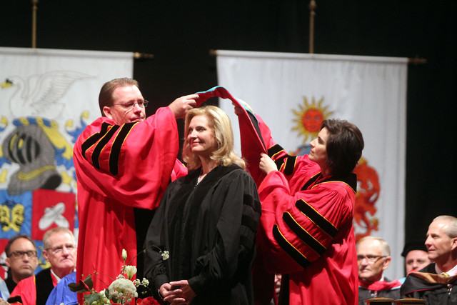 Board of trustees members Ann Marie Allen and Eric O. Leavitt place a hood on Ann Romney at Southern Utah University in Cedar City, Friday, May 2, 2014. Romney was the keynote speaker and received an honorary doctorate from SUU at commencement Friday morning. (Photo: Jasmine Lewis)