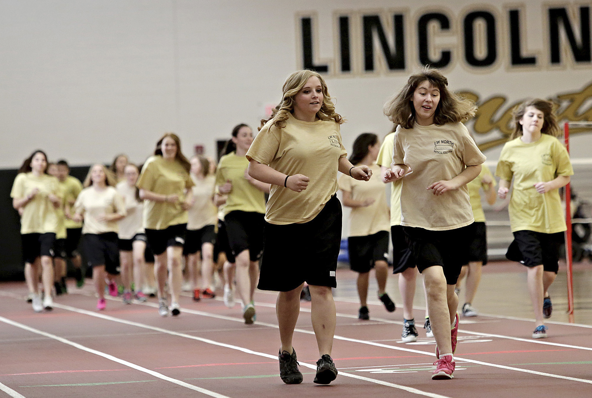 In this April 11, 2014 photo, adaptive physical education students run together on the track inside the field house at Lincoln-Way North High School in Frankfort, Ill. A new study by researchers at Utah State University found that half as many girls between 7 and 17 get the amount of exercise recommended by the state as boys.