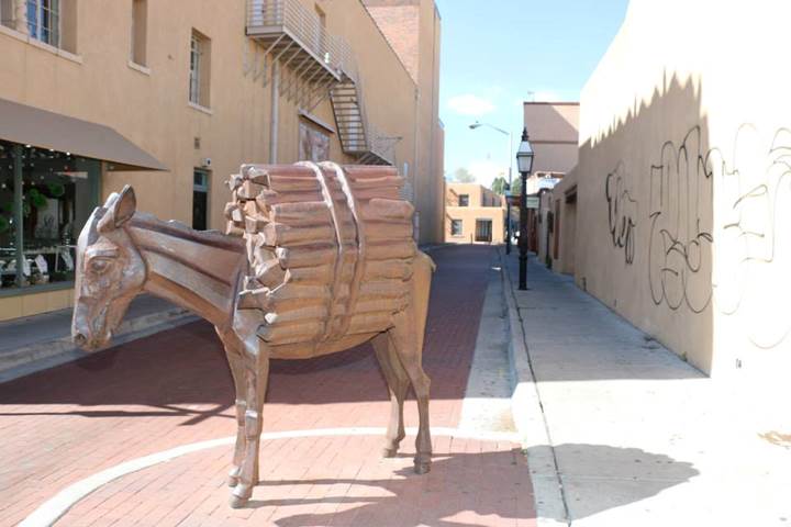 Santa Fe works to place tail of the donkey statue